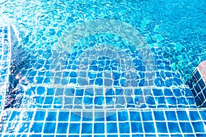 Concrete stair in swimming pool with blue ripped water wave