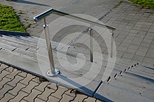 Concrete staircase with stainless steel polished tubular railing. cobblestones cobblestones concrete. screwed to the groung, detai
