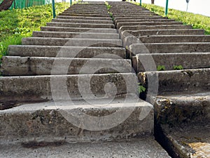 Concrete staircase on a steep slope of green grass