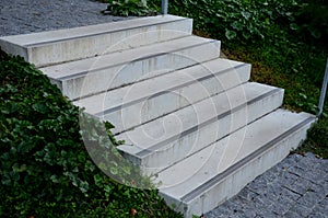 Concrete stairs to the park serving at the same time as a sitting bench. gray cement clean smooth bright cement surface. granite c