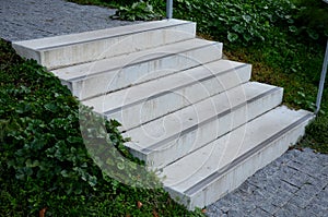 Concrete stairs to the park serving at the same time as a sitting bench. gray cement clean smooth bright cement surface. granite c