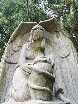 Concrete statue of an angel with a jug in the park