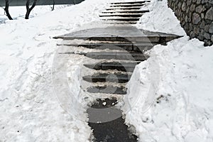 Concrete stone staircase covered with dirty deep slippery snow after blizzard snowstorm snowfall at city pedestrian