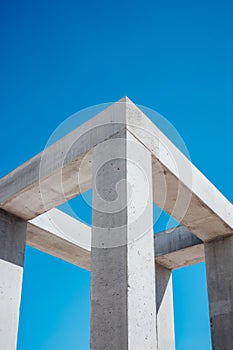 Concrete structure with blue sky in the background and few white columns. Generative AI