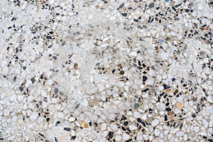 Concrete surface texture with multi-colored light and dark stones.