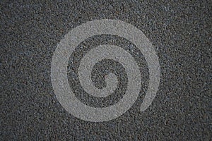 Concrete texture with blurred edges. Horizontal background of dark gray concrete floor with many small stones