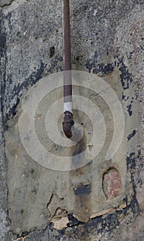 Concrete textured wall with rusty pipe.