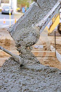 Concrete truck with pouring cement during to residential street sidewalk