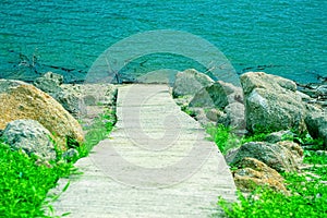 Concrete  walkway in the island go down to lake background