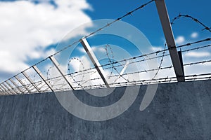 Concrete wall with barbed wire against blue sky. Concept border, prisons, refugees, loneliness. mixed media, copy space