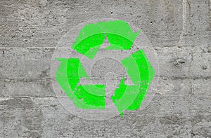 Concrete wall with green recycling logo sign