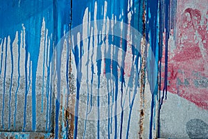 Concrete wall, stains of red and blue paint, graffiti