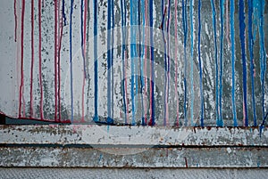 Concrete wall, stains of red and blue paint, graffiti