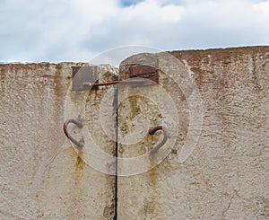 Concrete wall sticking out of it's rusty hinges for transportation