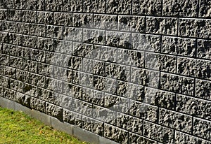 Concrete wall from texture blocks. high dividing noise wall of the yard. The wall is equipped with a sheet metal roof, which preve