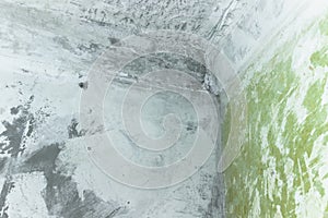 Concrete walls and ceiling with streaks of lime paint and putty during renovation