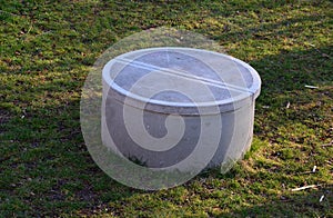 Concrete well of the well covered with a round concrete lid. the hatch is heavy so that children cannot open it. a fall into a wel