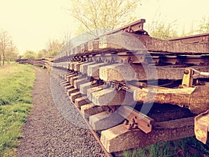 Concrete and wooden sleepers extracted with rail rods in railway station stock waiting for transport to steel foundry