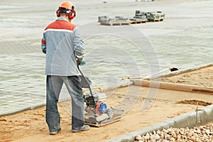 Concrete worker work with compactor