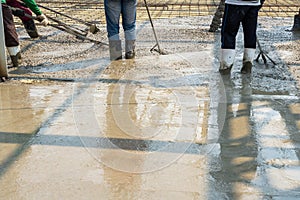 Concreters adjusting concrete mix.