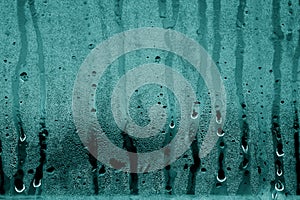 Condensation drops on glass in cyan tone.