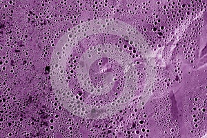 Condensation drops on plastic transparent material in purple ton