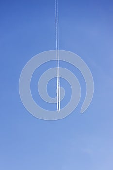 Condensation light line in the sky from aircraft. Trail of the plane on blue background. Airplane with white trace in clear sky. h