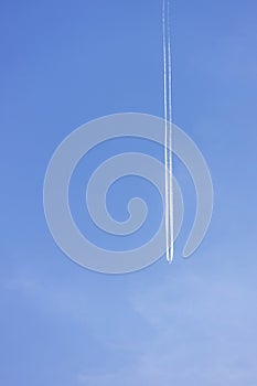 Condensation light line in the sky from aircraft. Trail of the plane on blue background. Airplane with white trace in clear sky. h