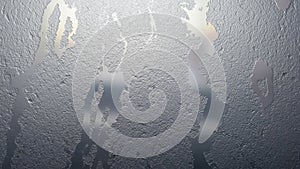 Condensation patterns on a window create a textured frosty surface