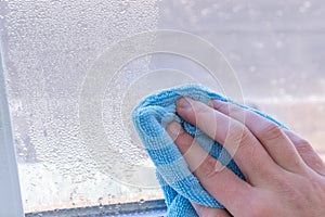 Condensation on windows in winter, wiping with a dry cloth photo