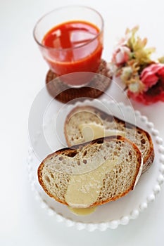 Condense milk and french bread on plate with vegetable juice