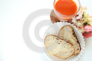 Condense milk and french bread on plate with vegetable juice