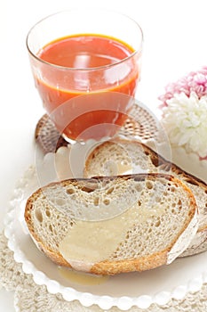 Condense milk and french bread on plate with vegetable juice