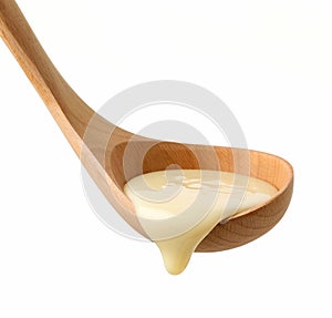 condensed milk in wooden ladle