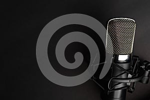 Condenser black studio microphone on a black background. Streamer, podcasts, music background