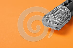 Condenser microphone on color background, space for text