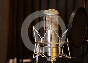 Condenser microphone in modern recording studio.