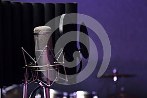 Condenser microphone in modern recording studio.