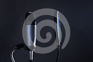 Condenser microphone with pop filter isolated on dark background