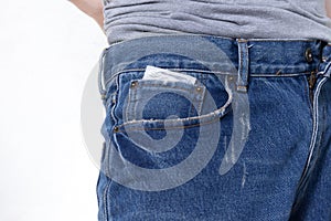 Condom in the pocket of blue jeans on isolated white background