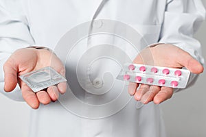 Condoms and contraceptives in the hands of a doctor for safe sex