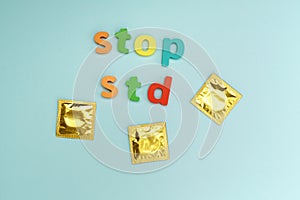 Condoms STOP STD text on blue background. Safe sex concept. Healthcare concept, world AIDS day. Flat lay