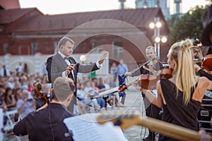 Conductor directing orchestra performance on the street