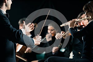 Conductor directing symphony orchestra photo