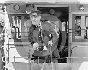 Conductor on a horse drawn streetcar holding the reins photo