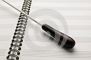 Conductor`s baton on open lead sheet, closeup photo
