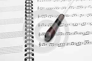 Conductor`s baton on sheet music book, closeup photo