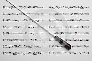Conductor`s baton on sheet music, top view photo