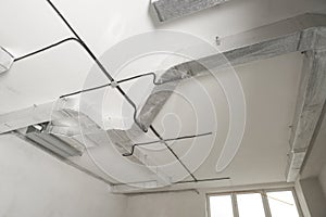 Tubi cavi un ventilazione sistema su bianco il soffitto Basso angolo. installazione da elettrico installazione 