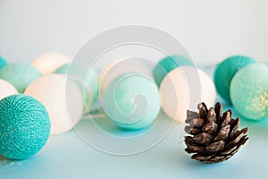 Cone on the blue background with blue and white lights made of yarn threads, closeup.